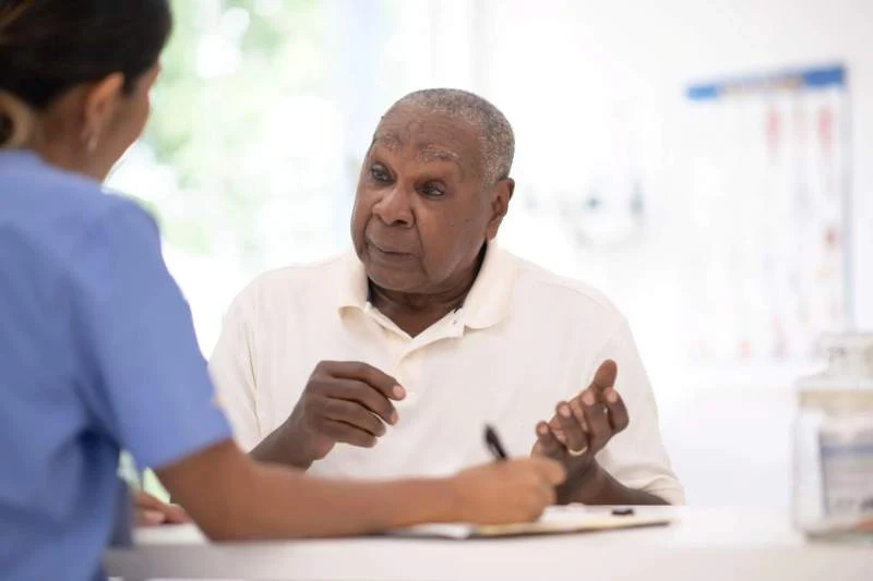 A macro image of a senior male patient having a caring and attentive follow-up consultation with a female healthcare provider at KELH.
